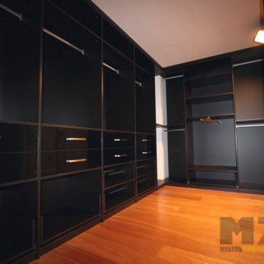 Большая гардеробная с закрытыми шкафами для хранения в темном цвете
