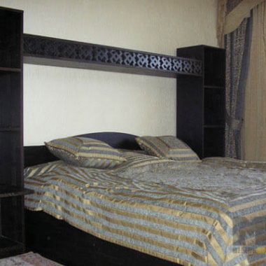Классическая черная двуспальная кровать с небольшой стенкой открытого типа